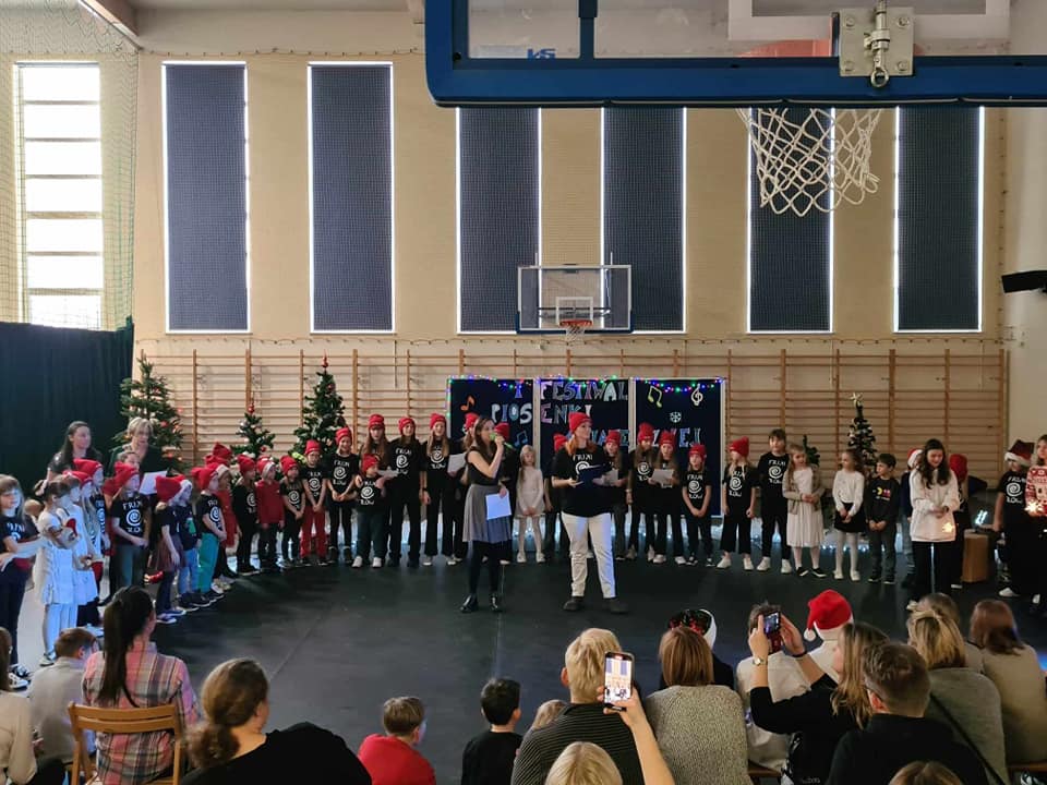 Dzieci występują na tle dekoracji świątecznej