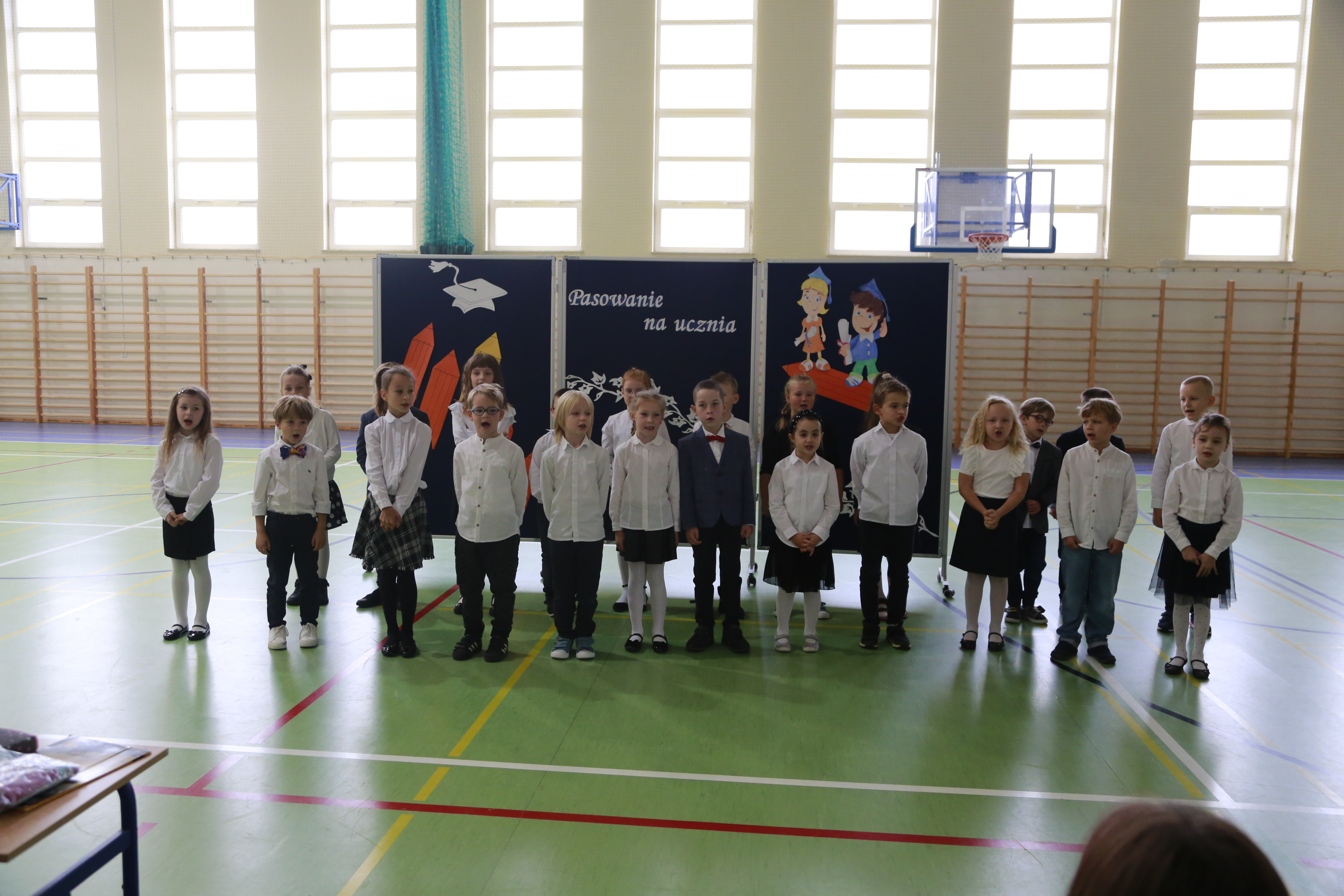 Uczniowie klasy pierwszej  na tle dekoracji