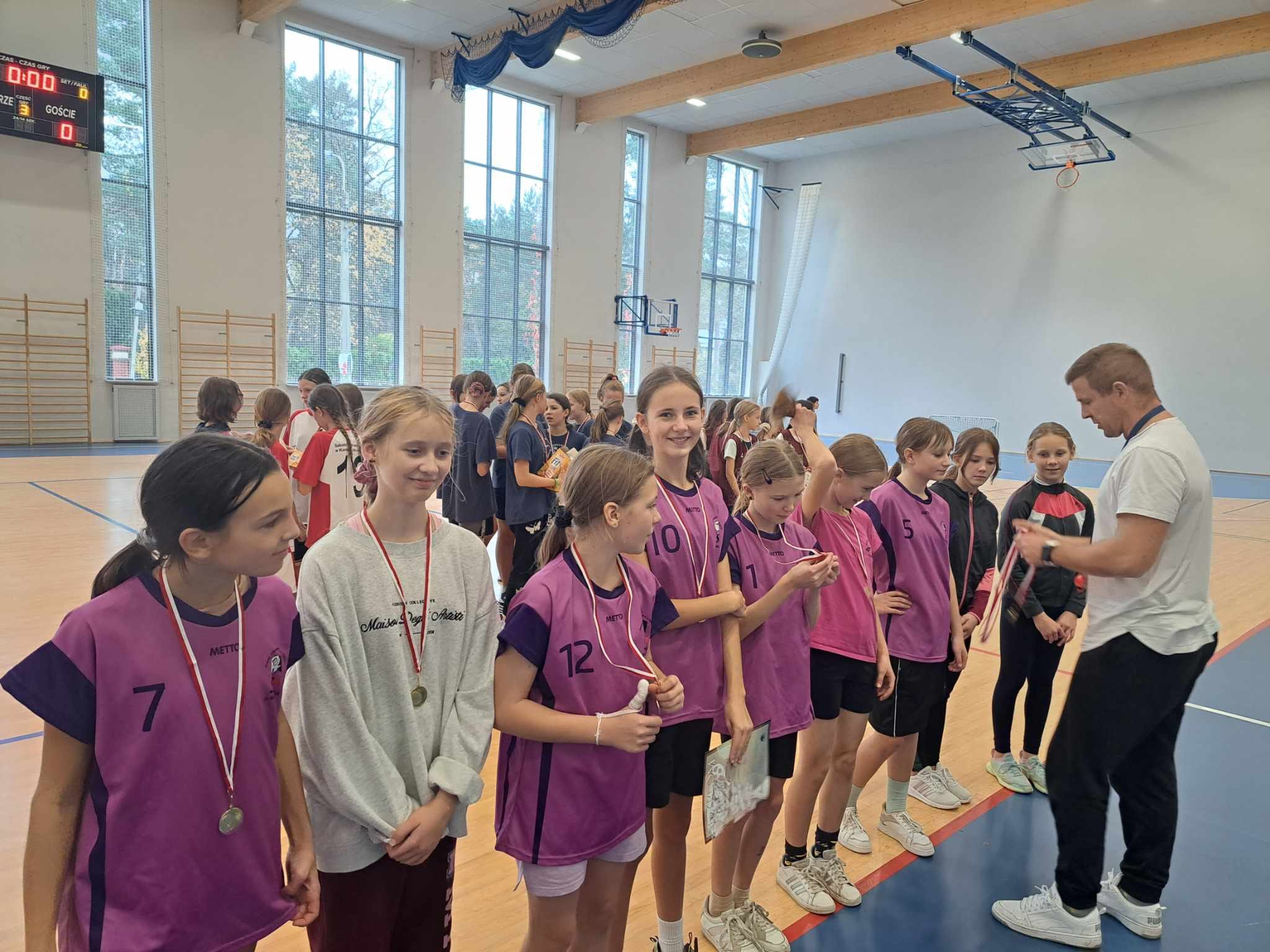 Uczennice stoją w szeregu, dostają medale.